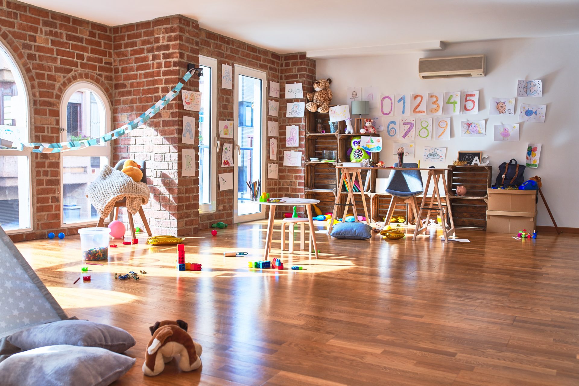 Preschool playroom with colorful furniture and toys around empty room